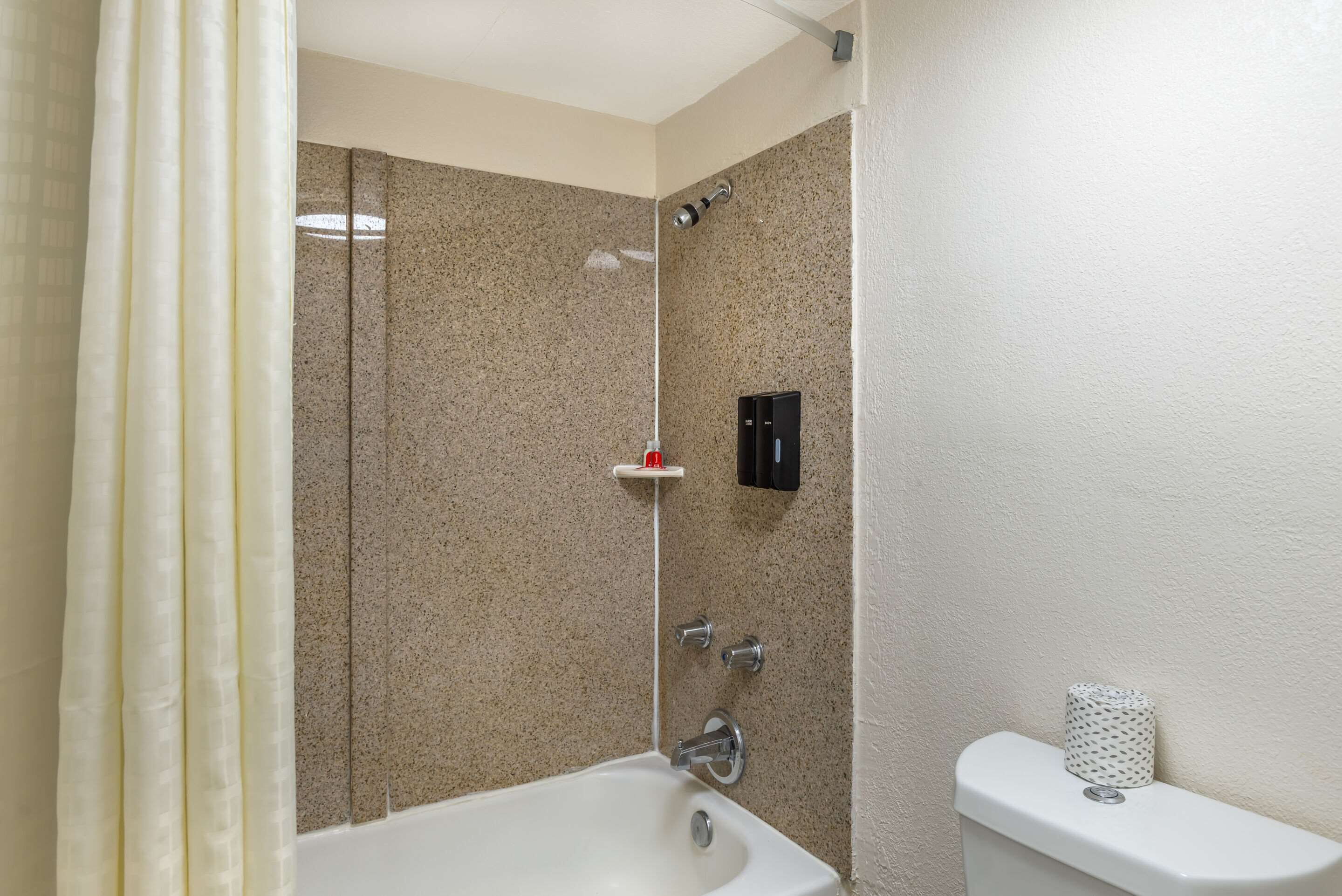 Un baño con bañera, inodoro y zona de ducha.