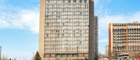 Un edificio de hotel alto con una cuadrícula de ventanas y un letrero que dice "Sandman" en la parte superior.