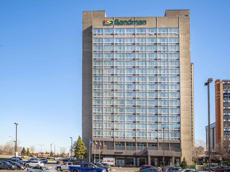 A tall building with the Sandman logo, featuring a grid of windows and a flat roof.