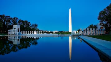 Um grande obelisco no centro, com um lago refletor à frente.