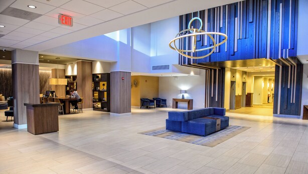A spacious lobby with a reception desk, seating area, and a modern chandelier. - Crowne Plaza Dulles Airport by IHG (Herndon)