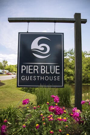 Un letrero del Hostal Pier Blue, con logotipo y nombre.