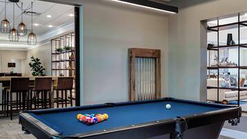 Relax and socialize in this spacious room featuring a pool table, comfortable seating, and a bar area.