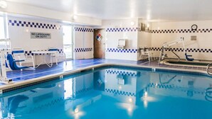 An indoor swimming pool with blue tiled walls, a lifeguard chair, and a sign indicating no lifeguard on duty. - Quality Inn & Suites Golden - Denver West (Golden)