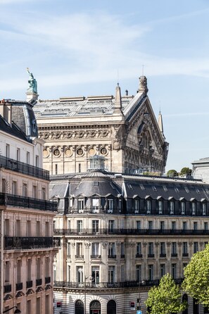 A historic building with classical architecture, featuring ornate facades and a prominent statue.