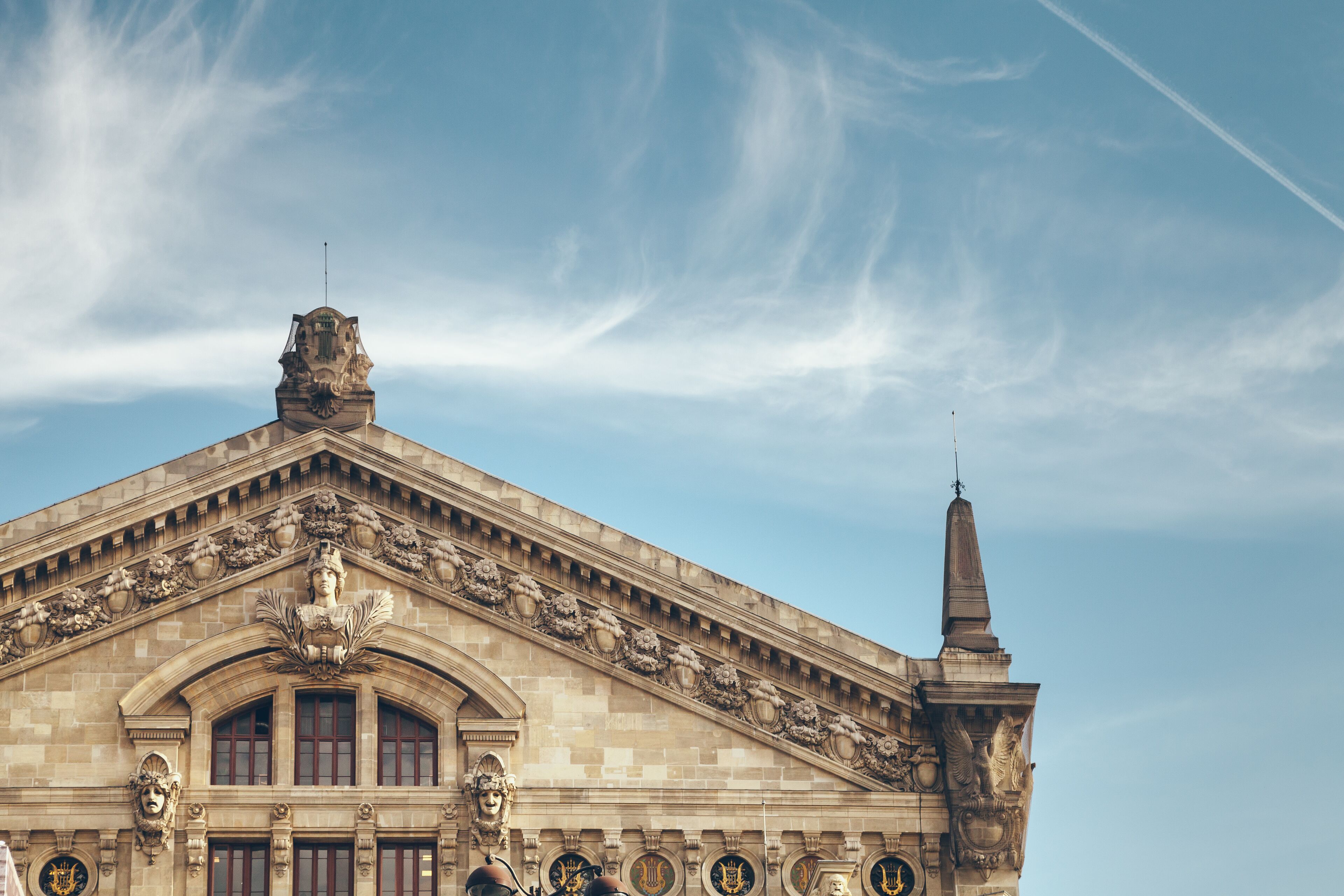 A historic building with ornate architectural details, including a prominent clock tower and decorative sculptures.