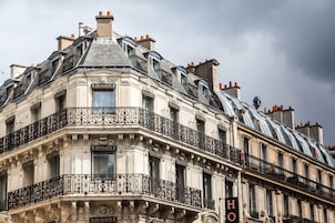 Un edificio ad angolo con balconi decorati e la scritta "Excelsior" sulla facciata.
