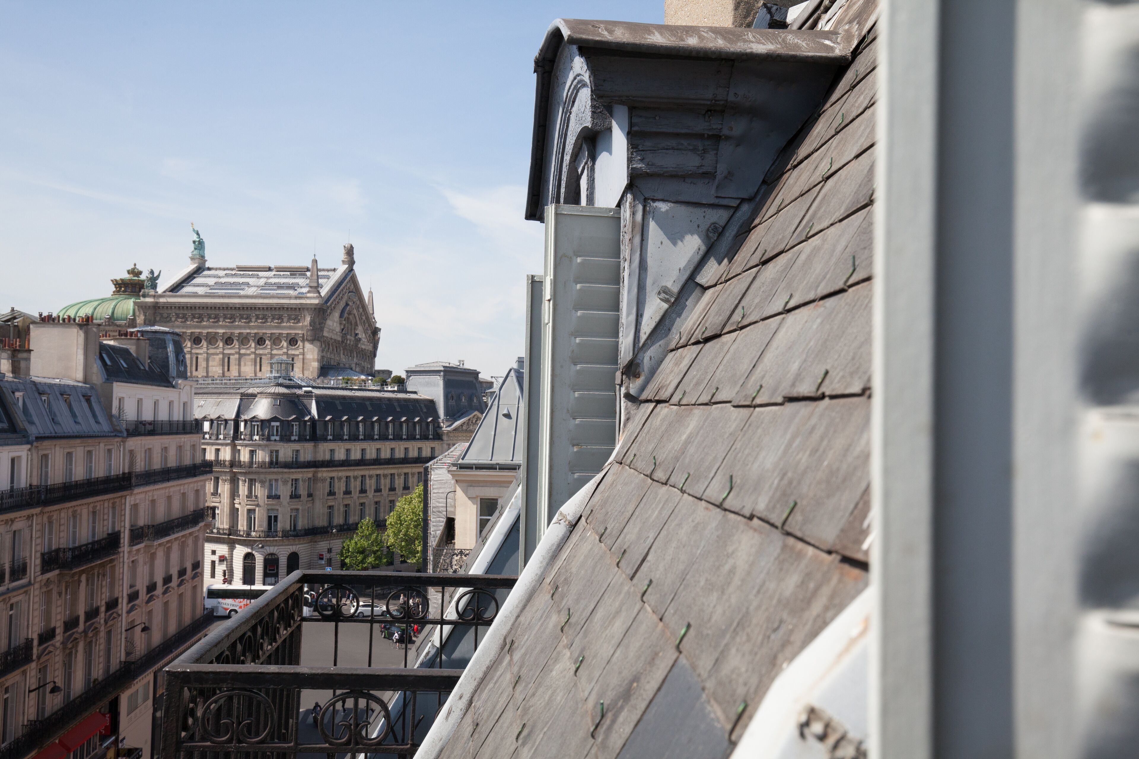 A view of a building with a sloped roof and a balcony.