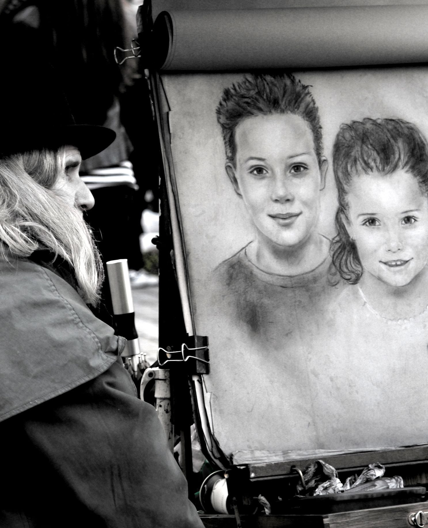 Una persona pintando un retrato sobre un lienzo.
