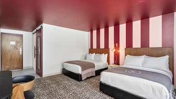 Una habitación de hotel con dos camas, un escritorio y una silla.