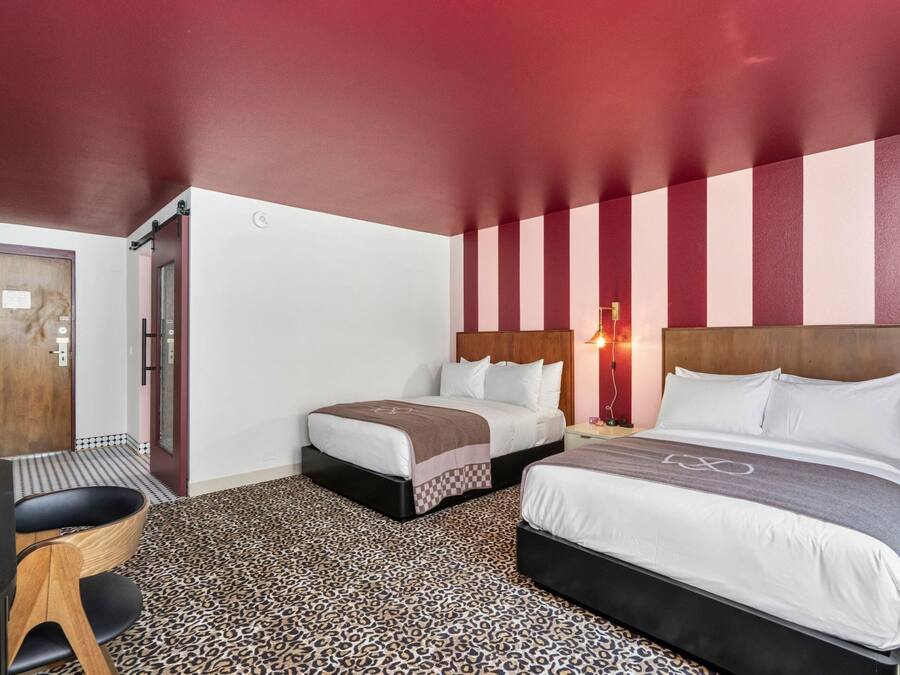 Una habitación de hotel con dos camas, un escritorio y una silla.