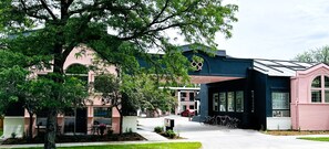 A building with a pink facade, a black section with a unique design, and a tree in the foreground. - The Buxton, BW Signature Collection by Best Western (Fort Collins)