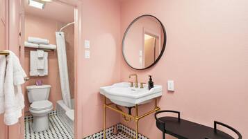 A bathroom with a toilet, sink, and shower.