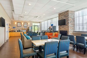 Relax in our spacious seating area with comfortable tables and chairs, a flat-screen TV, and a fireplace.