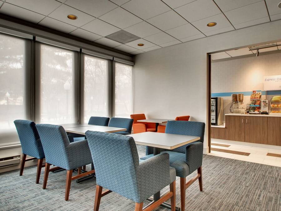 A conference room with a large table, blue chairs, and a kitchenette area with a sign reading "Express Start".