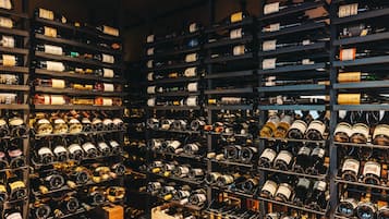 A wine cellar with numerous wine bottles organized on shelves.