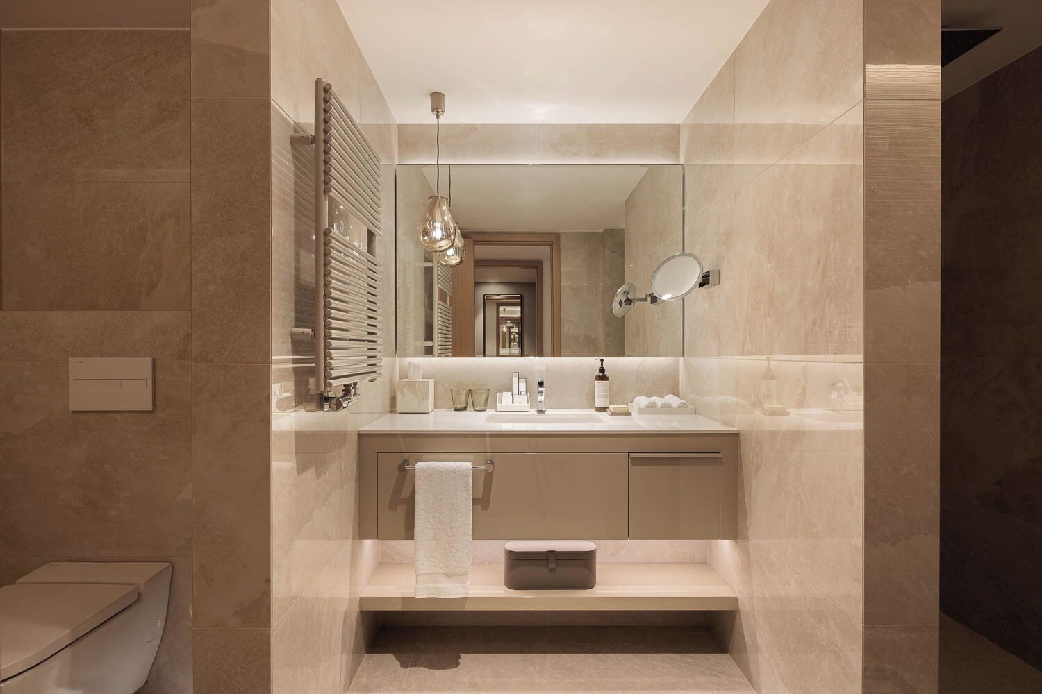 A modern bathroom with a large mirror, a towel rack, and a built-in toilet.