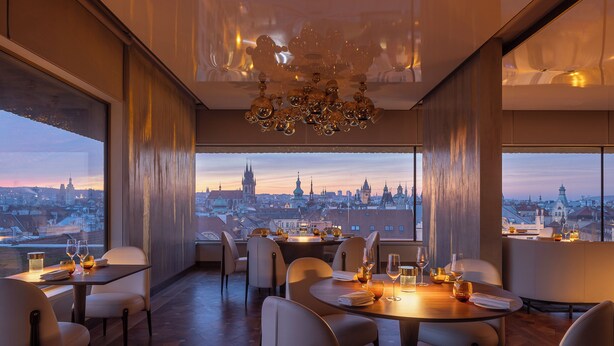 Un restaurant avec vue sur la ville, un décor moderne et un lustre.