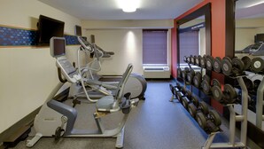 A gym with cardio equipment, a mirror, and a rack of dumbbells. - Hampton Inn by Hilton Chester South (Chester)