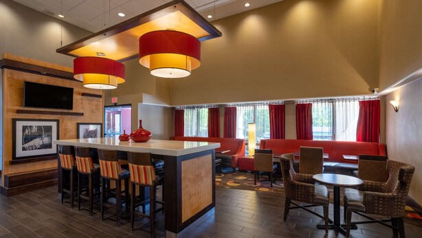 A hotel lobby with a bar area, seating, and a television. - Hampton Inn by Hilton Chester South (Chester)