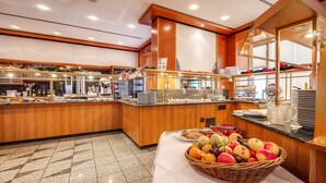 Un espace buffet proposant une variété de plats et un panier de fruits sur une table.