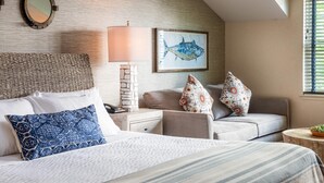 A hotel room with a bed, a sofa, a lamp, a wall-mounted mirror, and a framed fish painting. - Edgar Hotel Martha's Vineyard, an Ascend Collection Hotel (Edgartown)