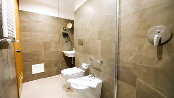 Une salle de bain moderne avec une douche à parois de verre, des toilettes, un lavabo et un miroir.