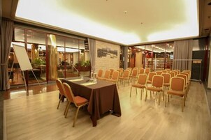 A conference room with a large table and chairs, large windows, and a view of the city.