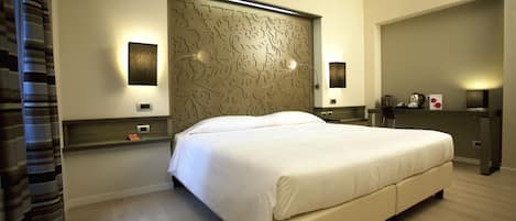 A modern bedroom with a large bed, a decorative headboard, bedside lamps, and a nightstand with a lamp.