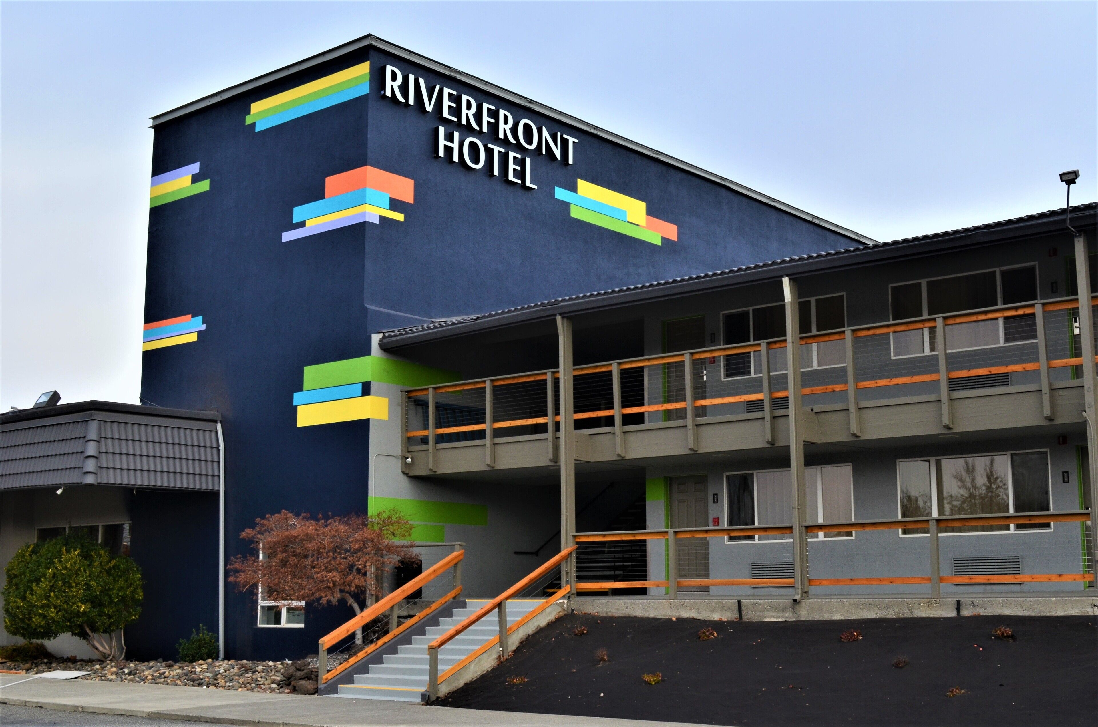 A hotel with a modern design, featuring a prominent sign that reads "RIVERFRONT HOTEL".