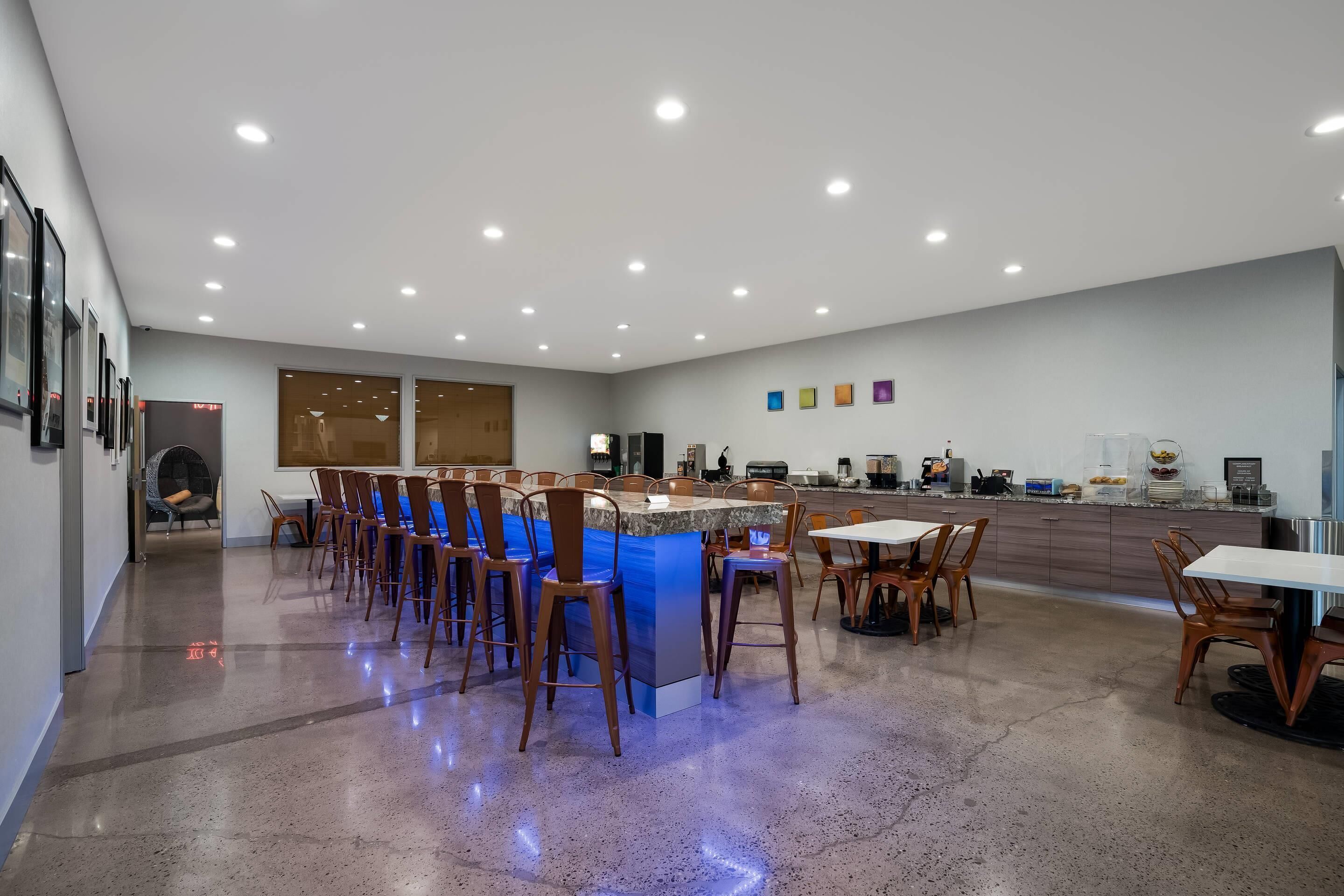 A spacious, well-lit kitchen area with a long counter, multiple bar stools, and a variety of kitchen appliances.