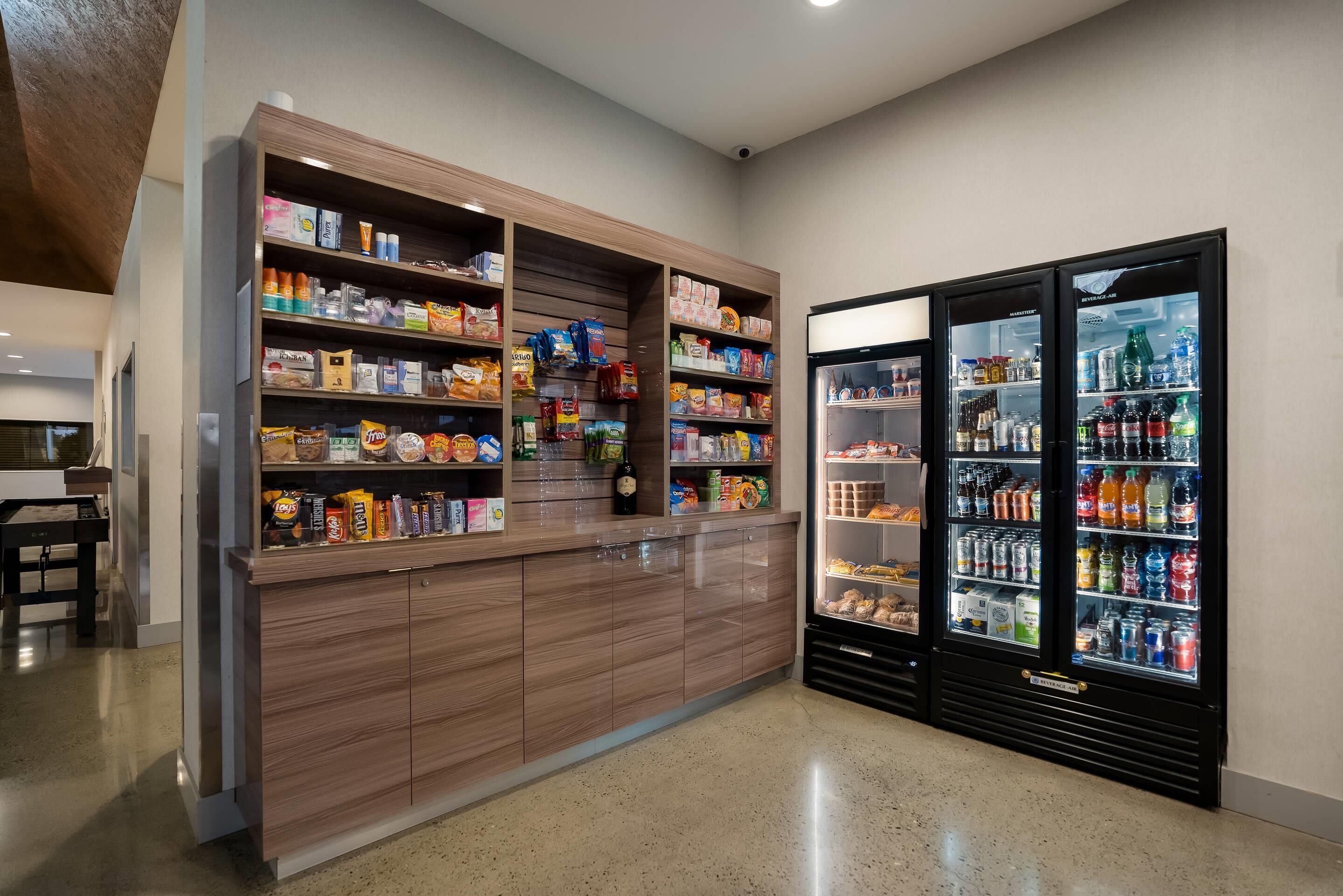 Un bar bien approvisionné proposant une variété de collations, de plats et de boissons, ainsi que deux distributeurs de boissons.