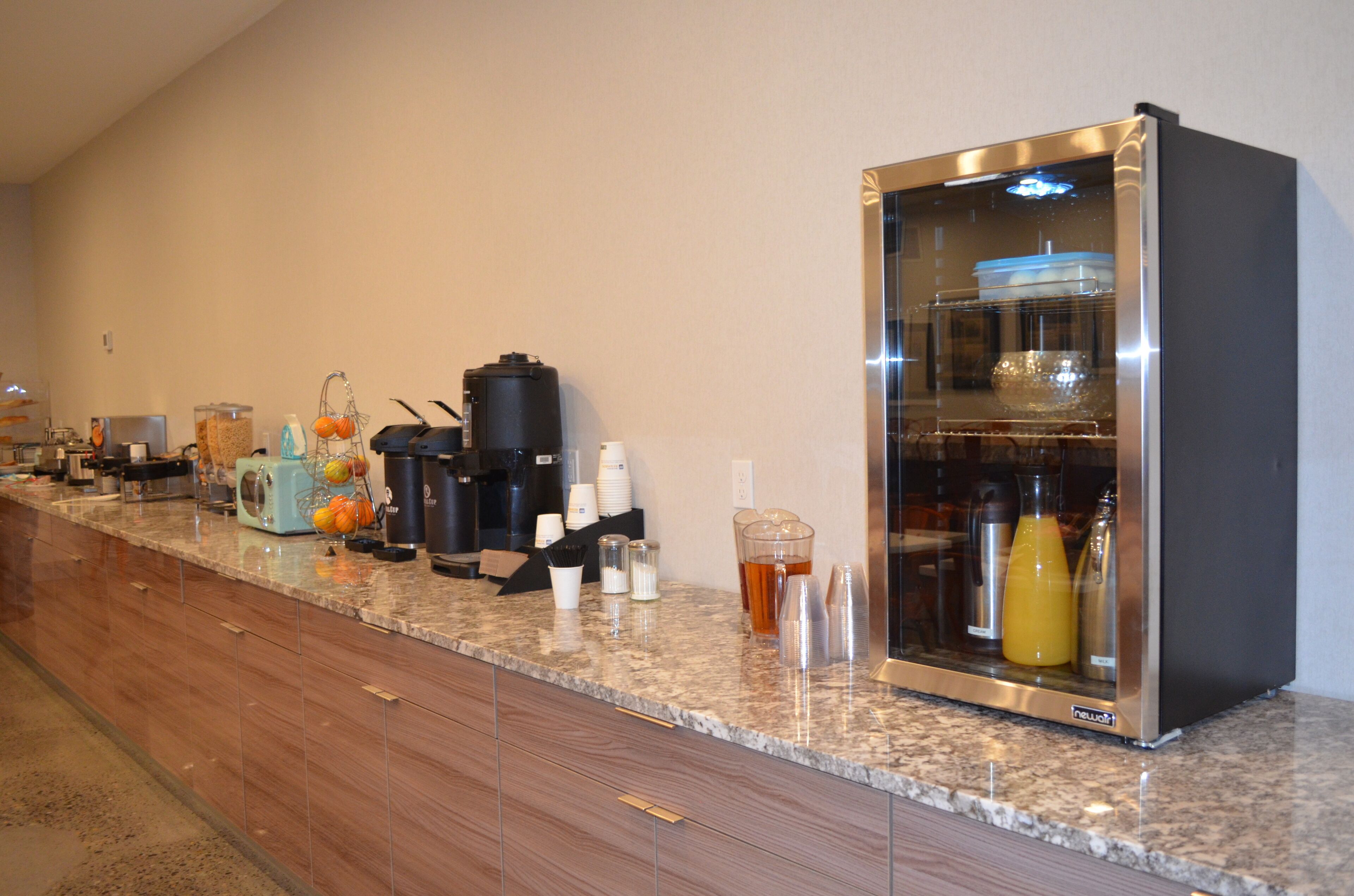 A self-service beverage station with coffee makers, a blender, and a refrigerator.