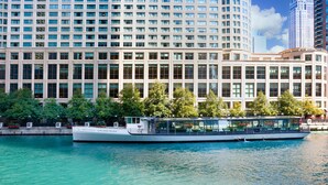 A modern building with a large glass facade and a river in front. - Sheraton Grand Chicago Riverwalk (Chicago)