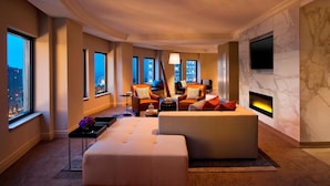 A modern living room with a fireplace, large windows, and a flat-screen TV mounted on the wall. - Sheraton Grand Chicago Riverwalk (Chicago)