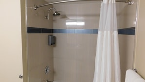 A shower with a glass door, a handheld showerhead, and a towel rack.