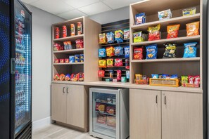 A snack and beverage vending area with various snack options and a refrigerated section.