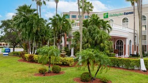 A Holiday Inn Express hotel with a landscaped garden, palm trees, and a fountain. - Holiday Inn Express Miami Airport Doral Area by IHG (Miami)