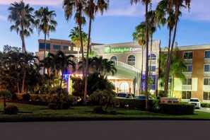 A Holiday Inn Express hotel with a modern facade, surrounded by palm trees and well-maintained landscaping. - Holiday Inn Express Miami Airport Doral Area by IHG (Miami)