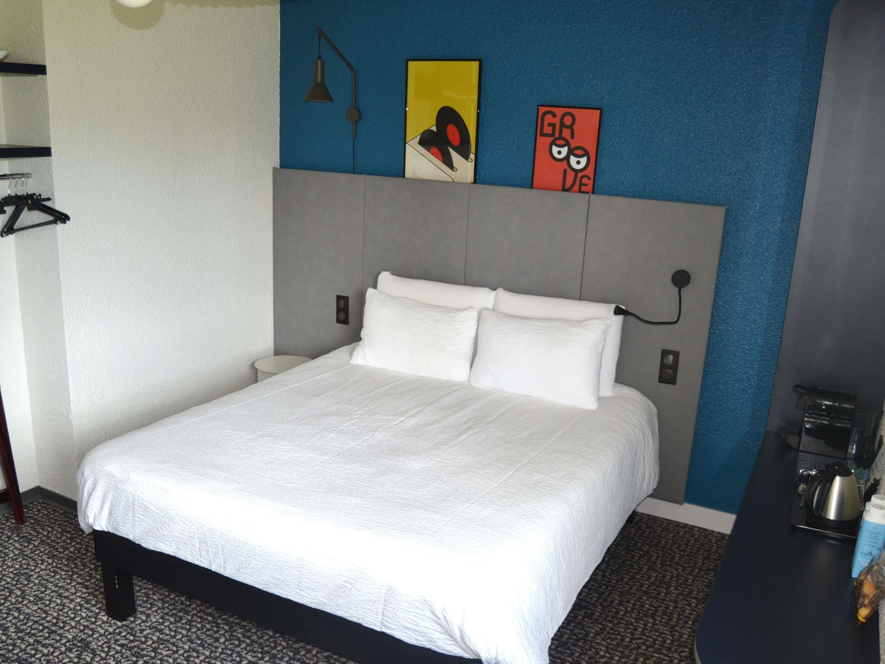 Una habitación de hotel con cama, escritorio y cafetera.