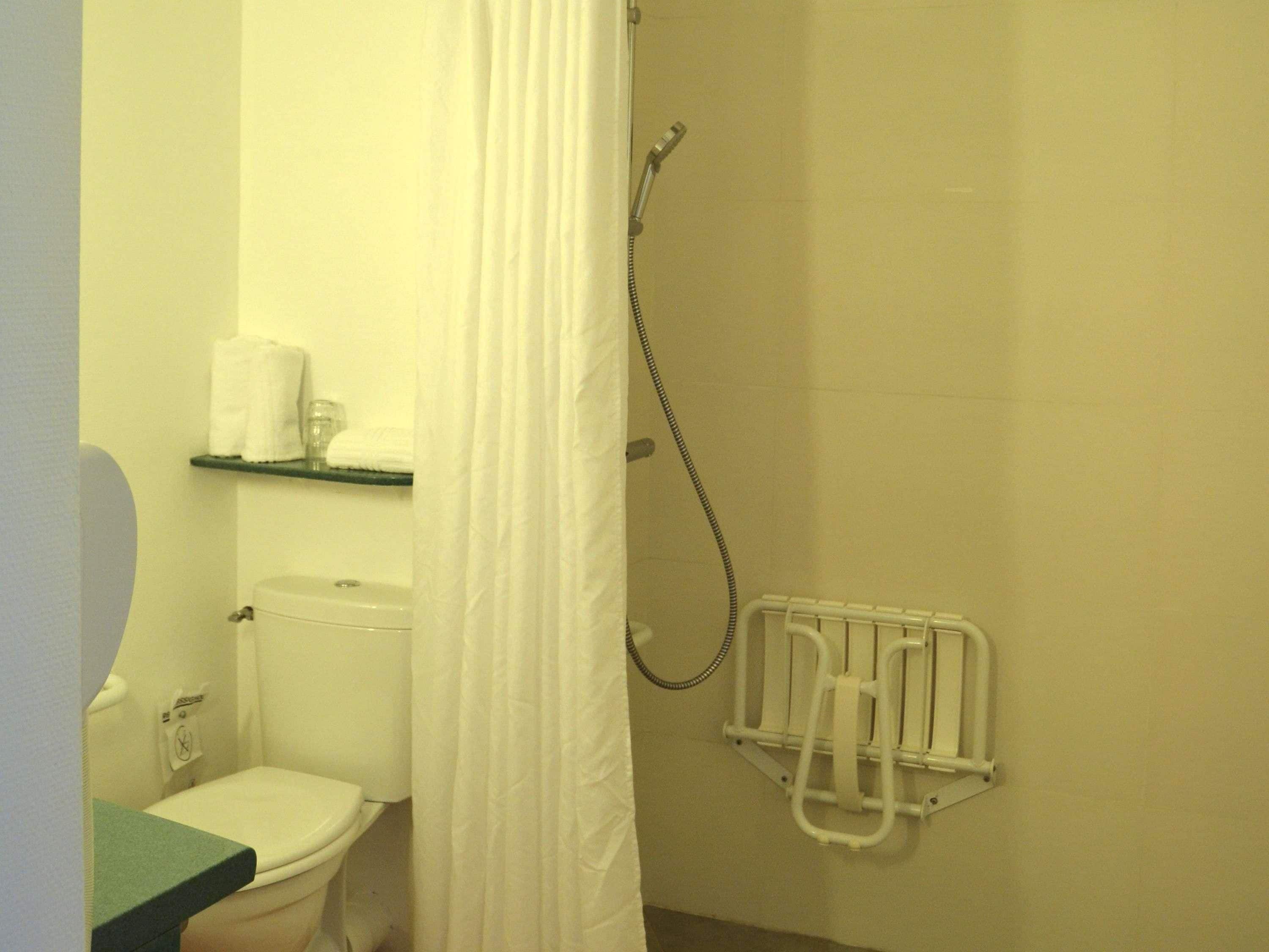 Un baño con inodoro, ducha y toallero.