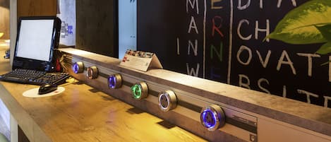 Un mostrador de recepción con una computadora portátil, un cartel y una pared con el texto "MEDIA MARCHINER".