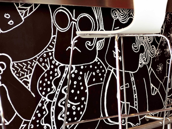 Primer plano de una superficie negra con dibujos lineales blancos de diversas formas y figuras abstractas.
