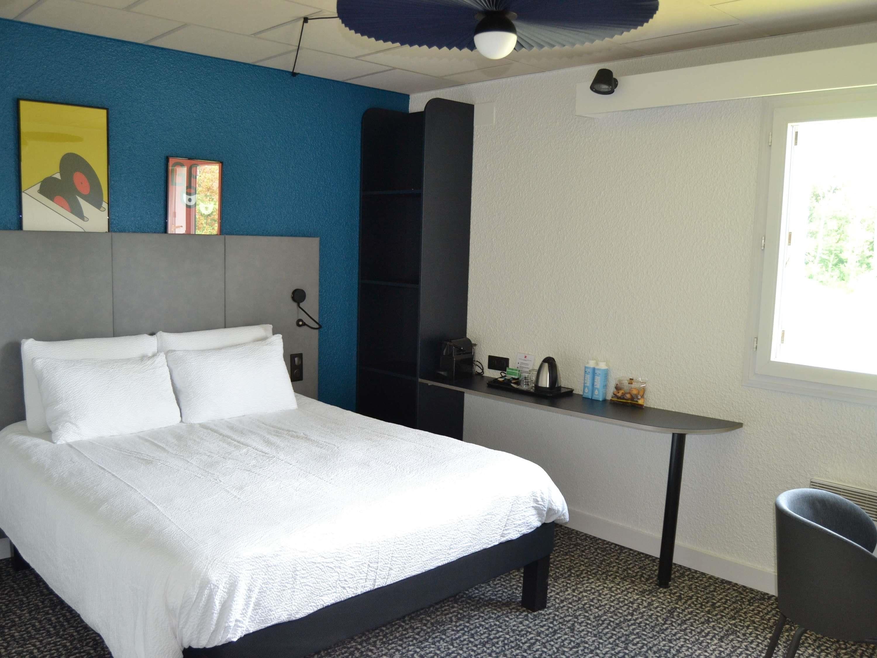 Ein Hotelzimmer mit einem Bett, einem Schreibtisch und einem Stuhl.