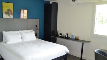 Ein Hotelzimmer mit einem Bett, einem Schreibtisch und einem Stuhl.