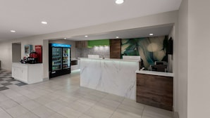 A modern kitchen with a marble island, a refrigerator, and a coffee machine. - Wyndham Garden Ankeny/Des Moines (Ankeny)
