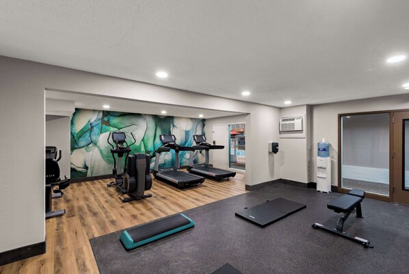 A gym with treadmills, a stationary bike, and a weight bench.
