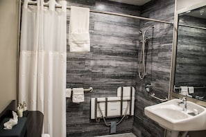 Bathroom features a shower, sink, and towel rack.