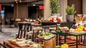 Ein reichhaltiges Buffet mit verschiedenen Speisen und Beilagen, darunter Salate, Früchte und Gemüse.