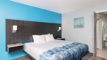 Habitación de hotel con cama, mesitas de noche y un cuadro en la pared.
